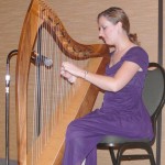 Executive assistant Laura Welker entertains on the Celtic harp during the silent auction.